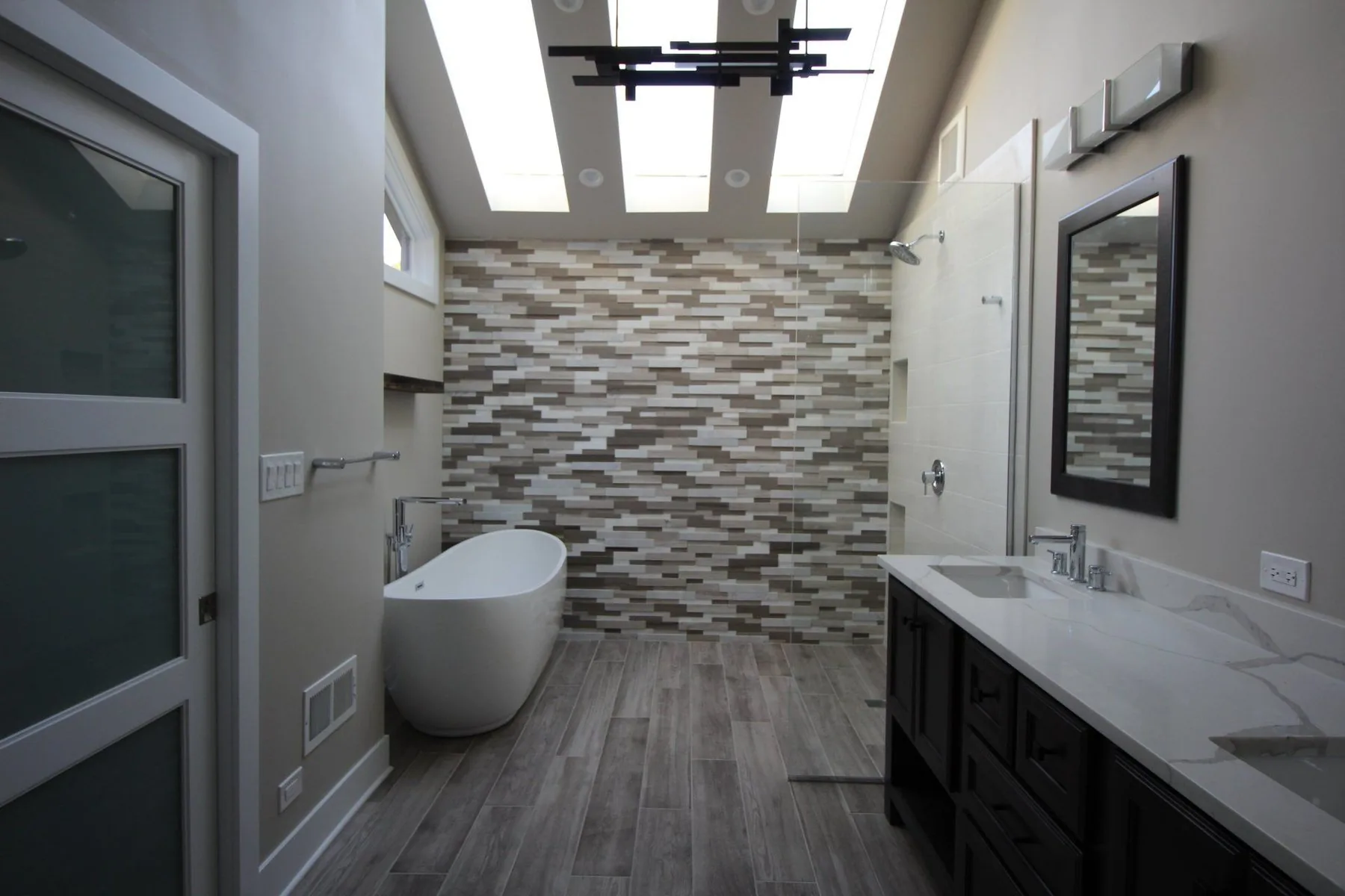 Master bathroom remodel with freestanding tub, stone accent wall and skylights