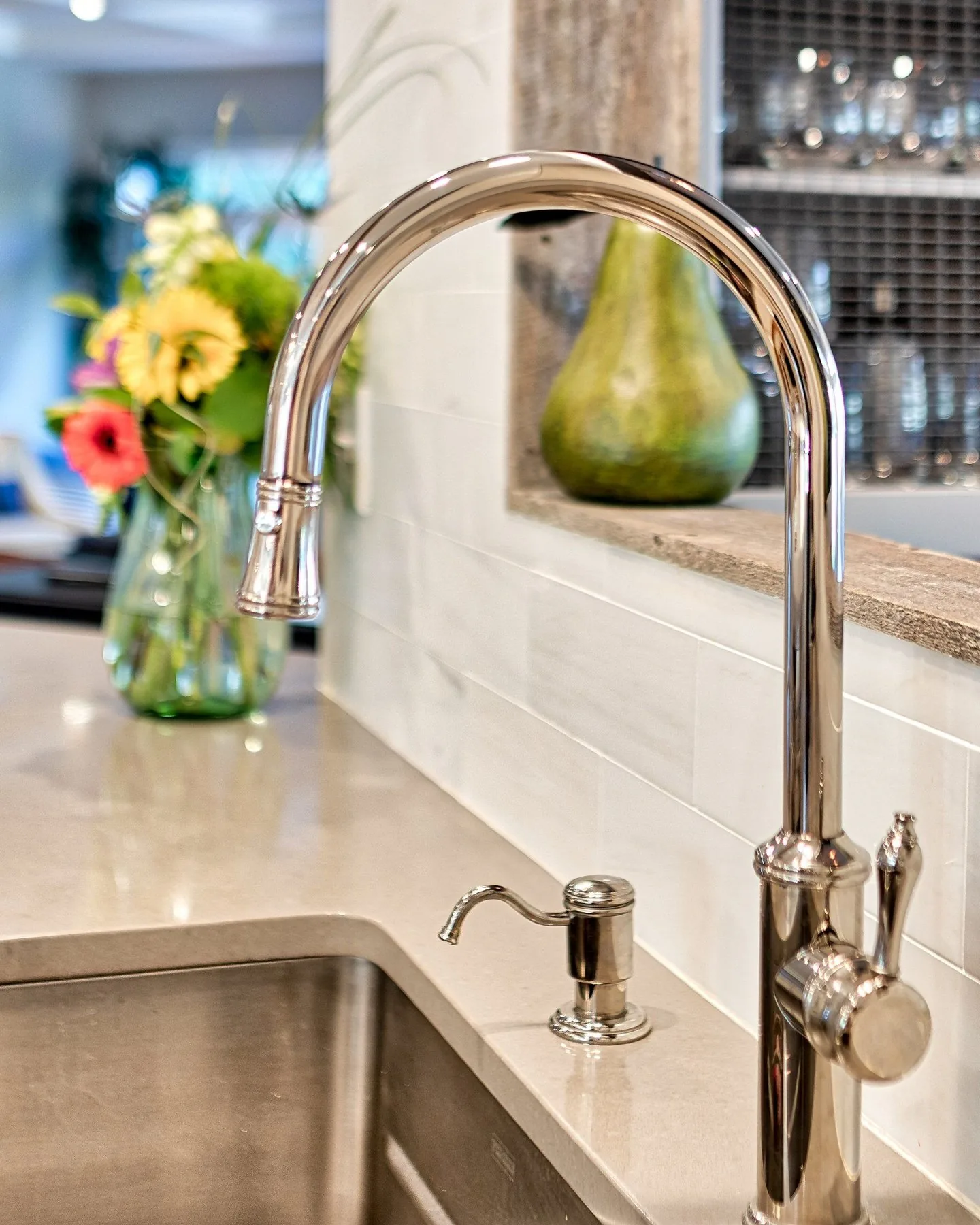 Polished faucet and soap dispenser detail on a quartz counter